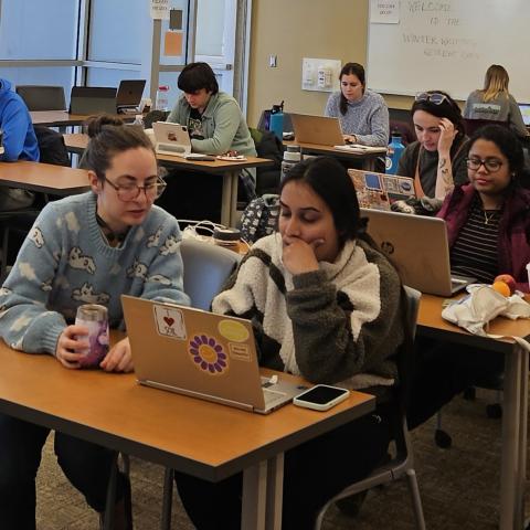 Students collaborate on a computer in a classroom